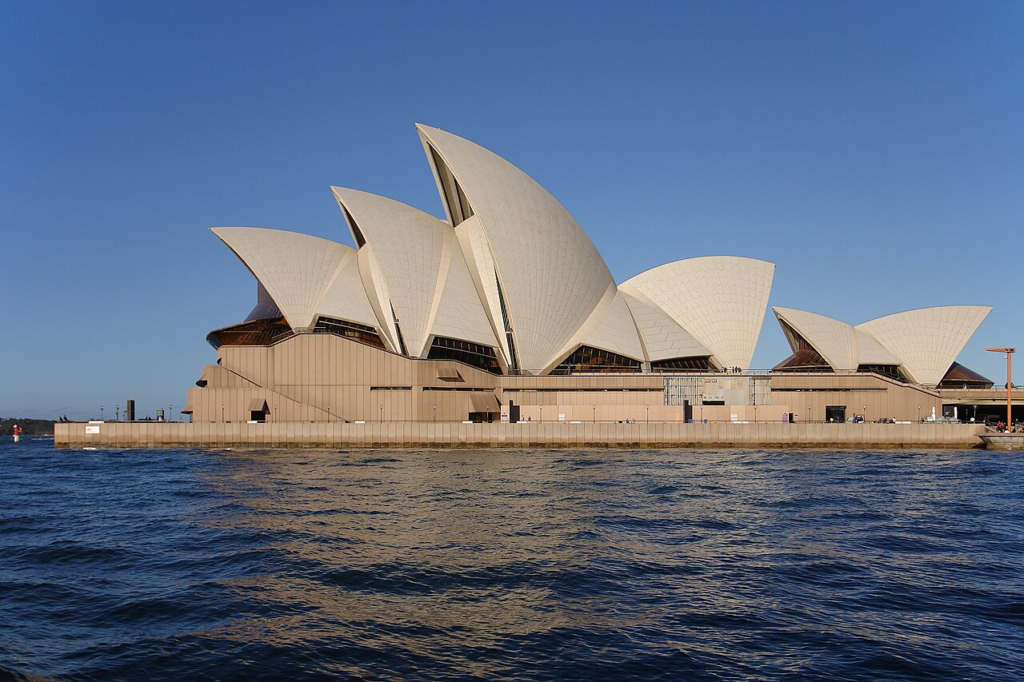 Sydney Opera House viewed across Sydney Harbour, representing the capacity of internationally exchanged architectural ideas to become inseparable from a particular place