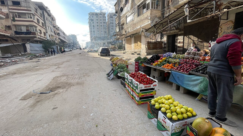 Gaza’s Reconstruction: Who Gets to Decide What Comes Back? 7 A functioning vegetable market along a damaged commercial street in Gaza, photographed in February 2025