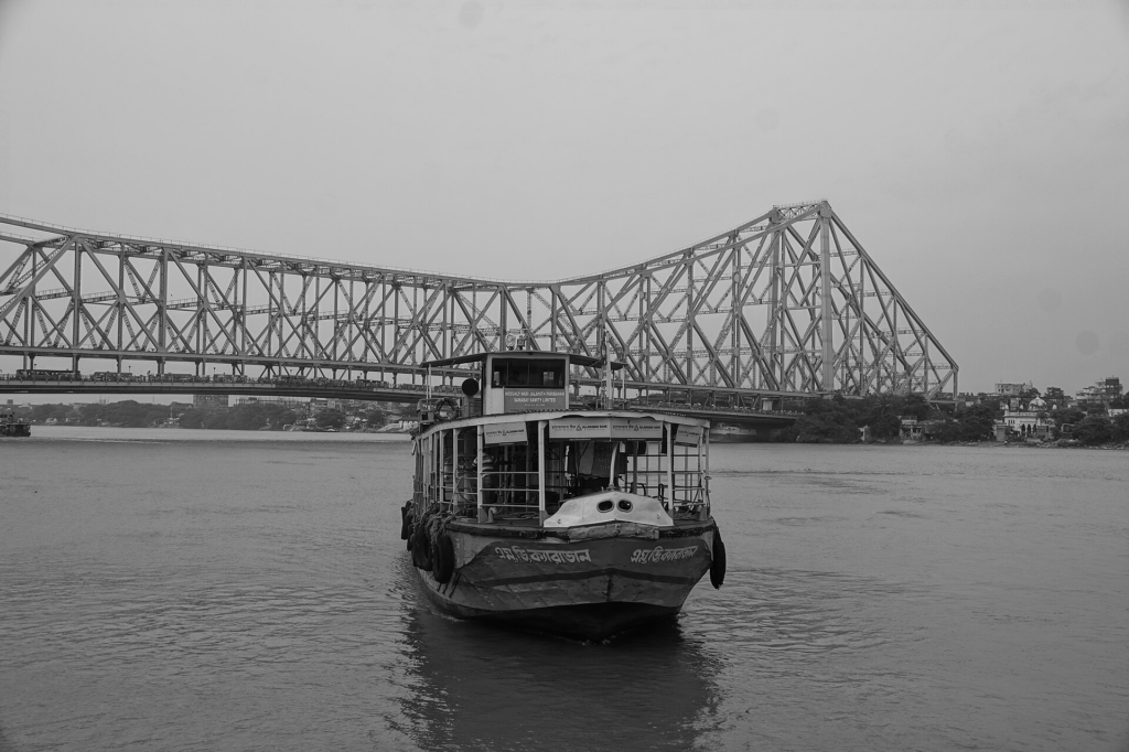 Ferry passing beneath Howrah Bridge in Kolkata